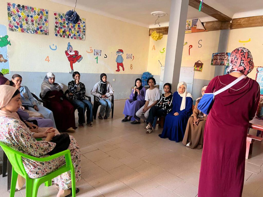 WhatsApp Bild 2025-11-03 um 14.05.17_d0101257 Die Teilnehmerinnen des zweiten Teenage-Girls-Clubs sitzen auf Stühlen und hören ihrer Lehrerin zu.