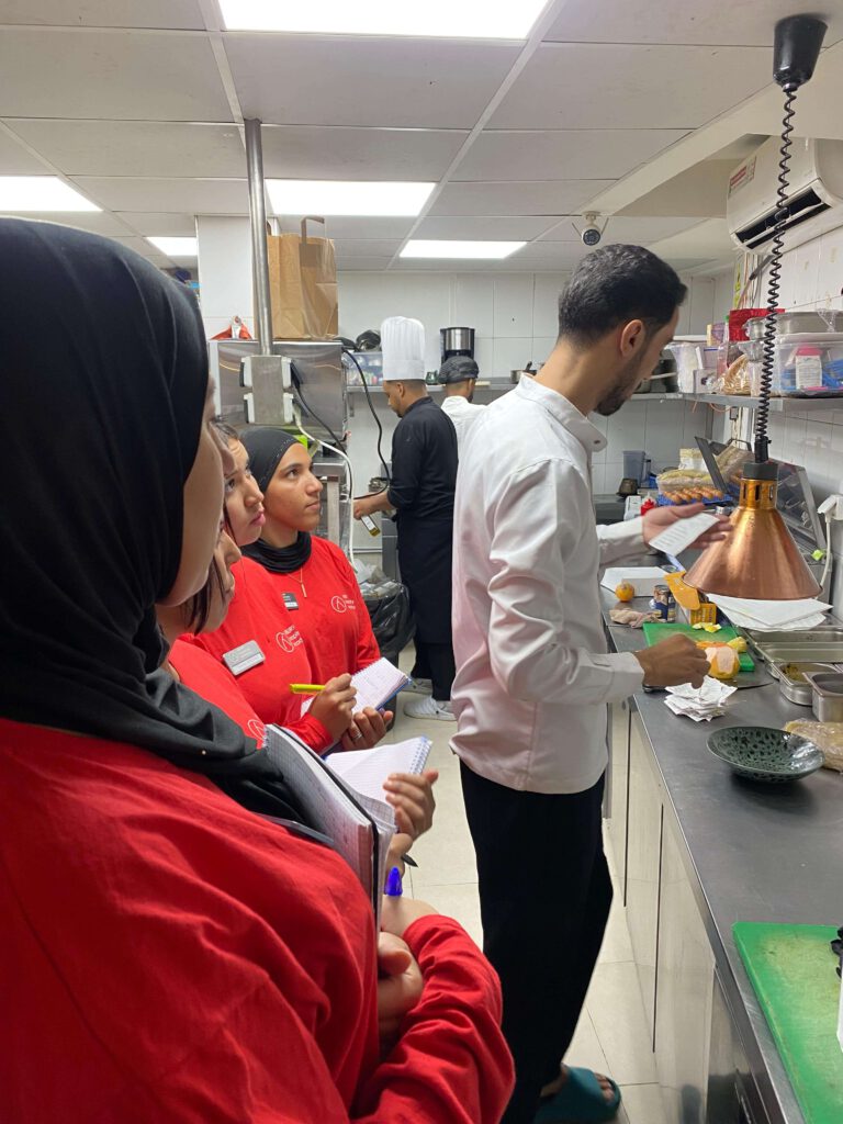 IMG-20251001-WA0011 Die Frauen der ABURY Hospitality Academy 2025 bei der Arbeit in der Küche während ihres Praktikums.