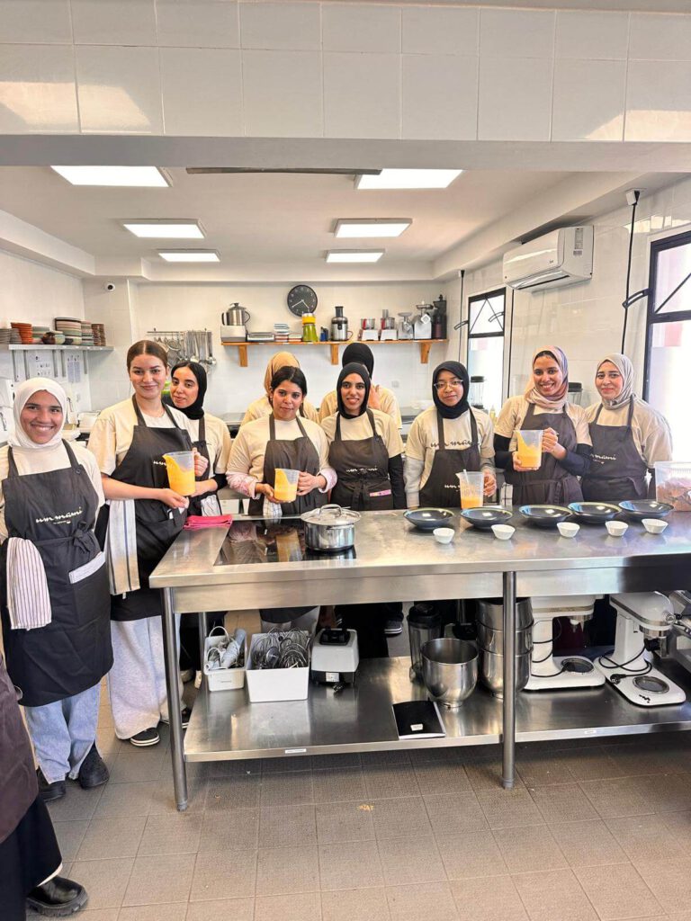 group photo Die Frauen der ABURY Hospitality Academy 2025 bei der Arbeit in der Küche während ihres Praktikums.